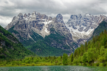 Green lake in the heart of the Dolomite Mountains. Moody landscape with turquoise water alpine lake...
