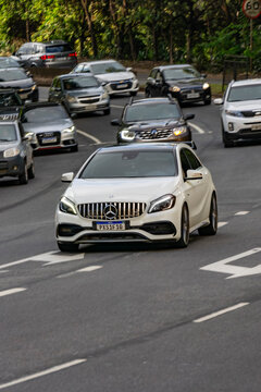 White Mercedes Benz A45 in city traffic, AMG Sportscar in movement, hot hatchback