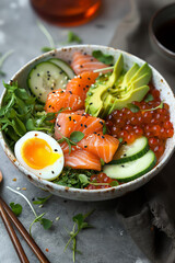 A bowl of salmon with avocado, eggs, and greens