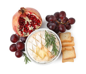 Tasty baked camembert, croutons, grapes and pomegranate isolated on white, top view