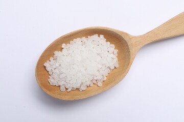 Natural salt in wooden spoon on white background, top view