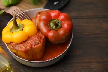 Delicious stuffed bell peppers served on wooden table. Space for text