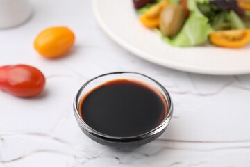 Vinegar in bowl on light textured table, closeup