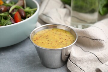 Tasty vinegar based sauce (Vinaigrette) in bowl on grey table, closeup