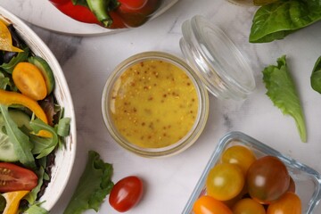Tasty vinegar based sauce (Vinaigrette) in jar, salad and products on white marble table, flat lay