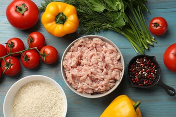 Making stuffed peppers. Ground meat and other ingredients on light blue wooden table, flat lay