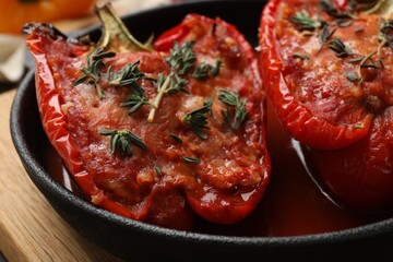 Tasty stuffed peppers in dish on table, closeup