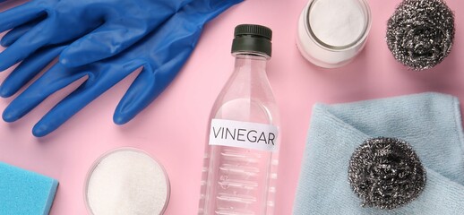 Eco friendly natural cleaners. Flat lay composition with bottle of vinegar on pink background