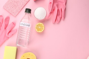 Eco friendly natural cleaners. Flat lay composition with bottle of vinegar on pink background,...