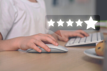 Woman leaving service feedback using laptop at table, closeup. Stars near device