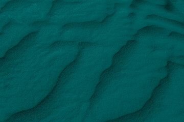 green desert sand shaped into waves by the wind