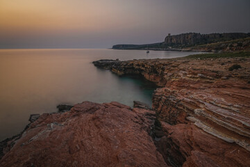 Italy,Sicily,Trapani district,San Vito Lo Capo,Mediterranean sea, Tyrrhenian sea,Gulf of Macari Makari illuminated in red in the early evening lights. June 2023