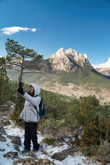 Girl taking a selfie on the emblematic mountain of Catalonia, Pedraforca. With its shape of two peaks. Vertical photography





