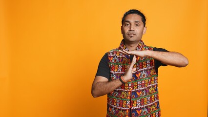 Portrait of assertive indian man asking for timeout, doing hand gestures, feeling fatigued. Firm...