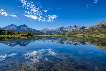 Naklejka premium Pristine Alpine Lake Reflecting Majestic Snow-Capped Mountains