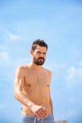 Young adult man with headache or sunstroke walking on the beach