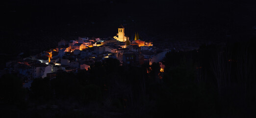 View from the hill of medieval historical city of Quesada in province of Jaen, with illuminated bell tower and while houses in the night time. Andalusia. Spain. Beauty in nature. Travel and tourism