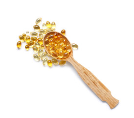 Wooden spoon with fish oil pills on white background