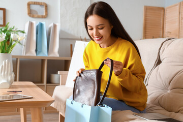 Young Asian woman with new bag at home. Online shopping