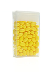 Yellow dragee pill mints candy packaging isolated on white background.