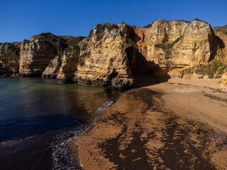 Obraz premium Praia de Dona Ana beach near Lagos town, Algarve, Portugal. Praia Dona Ana beach with turquoise sea water and cliffs, Portugal. Drone aerial view