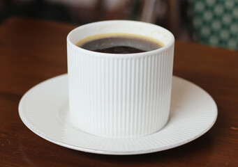 cup of coffee sits on plate in cafe.