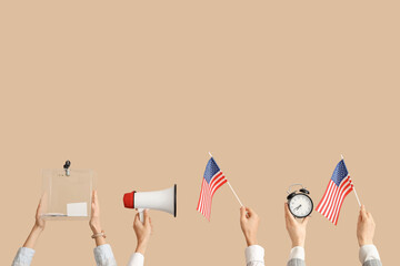 Hands with ballot box, USA flags, megaphone and alarm clock on beige background. Election concept
