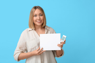 Woman with glucometer, sensor for measuring blood sugar level and blank paper on blue background. Diabetes concept