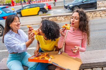 Friends sharing take away pizza while visiting a city