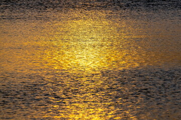 Riflessi dorati sul mare calmo  al tramonto 