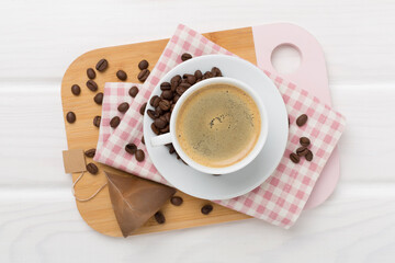 Cup of coffee made using pyramid on wooden background, top view