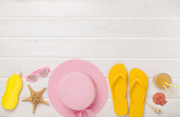 Flat lay with colorful beach accessories on wooden background. Vacation concept