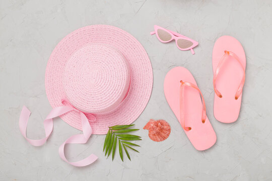 Flat lay with pink summer outfit on concreet background. Vacation concept