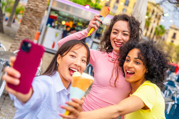 Friends taking selfie while eating ice cream in the city