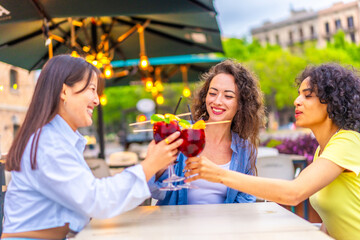 Friends toasting with cocktails enjoying summer in the city