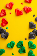 Symbolic Juneteenth top view vertical image: hearts in red, green, black on yellow, representing...