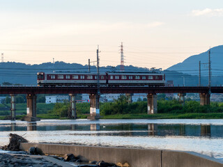 Fototapeta premium 早朝の大和川を渡る近鉄道明寺線の電車