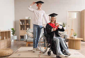 Female graduate in wheelchair with diploma and her classmate at home