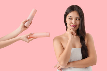 Thoughtful young Asian woman and hands with shampoo on pink background