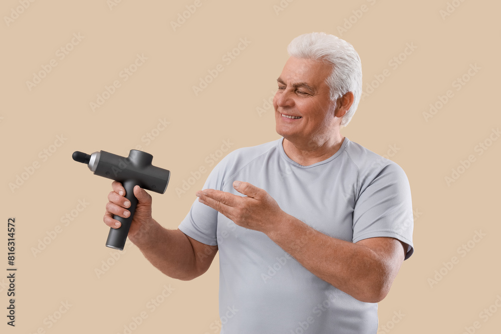 Sticker Mature man with percussive massager on beige background