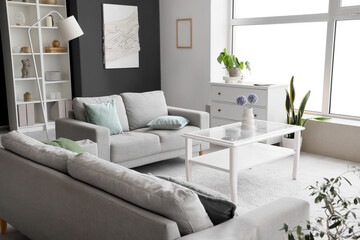 Interior of modern living room with grey sofas and glass coffee table