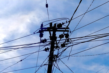 random Messy electrical cables and wires on electric pole on sky background.
