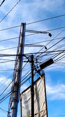 random Messy electrical cables and wires on electric pole on sky background.
