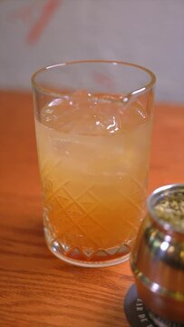 Vertical video of premium cocktails on wooden table. Slow motion cocktail videos. Concept of mixology and cocktails.