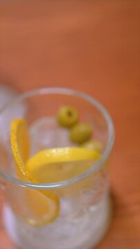 Vertical video of premium cocktails on wooden table. Slow motion cocktail videos. Concept of mixology and cocktails.
