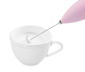 Whisking milk in cup with mini mixer (frother wand) isolated on white