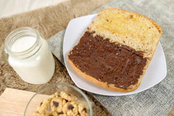 Bread with chocolate spread filling, milk and snack for breakfast