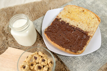 Bread with chocolate spread filling, milk and snack for breakfast