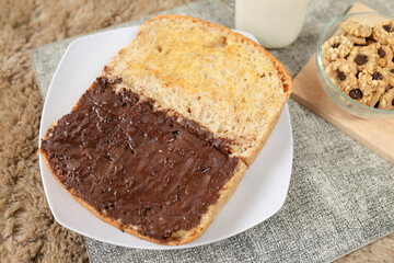 Bread with chocolate spread filling, milk and snack for breakfast
