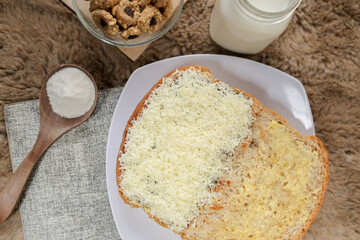 Bread with cheese, sweetened condensed milk, and butter. With white milk and snack on a table for breakfast	
